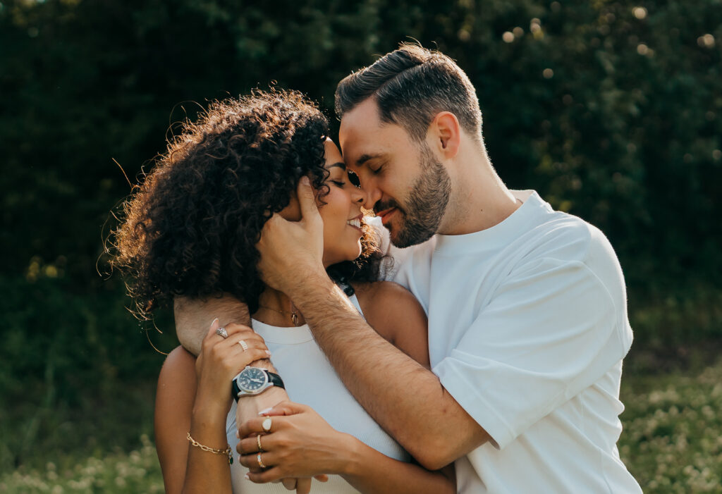 Liebendes Paar steht eng umschlungen in der Natur und genießt einen innigen Moment miteinander